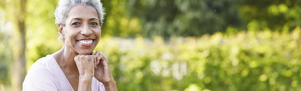 Photo of an older woman smiling in a field