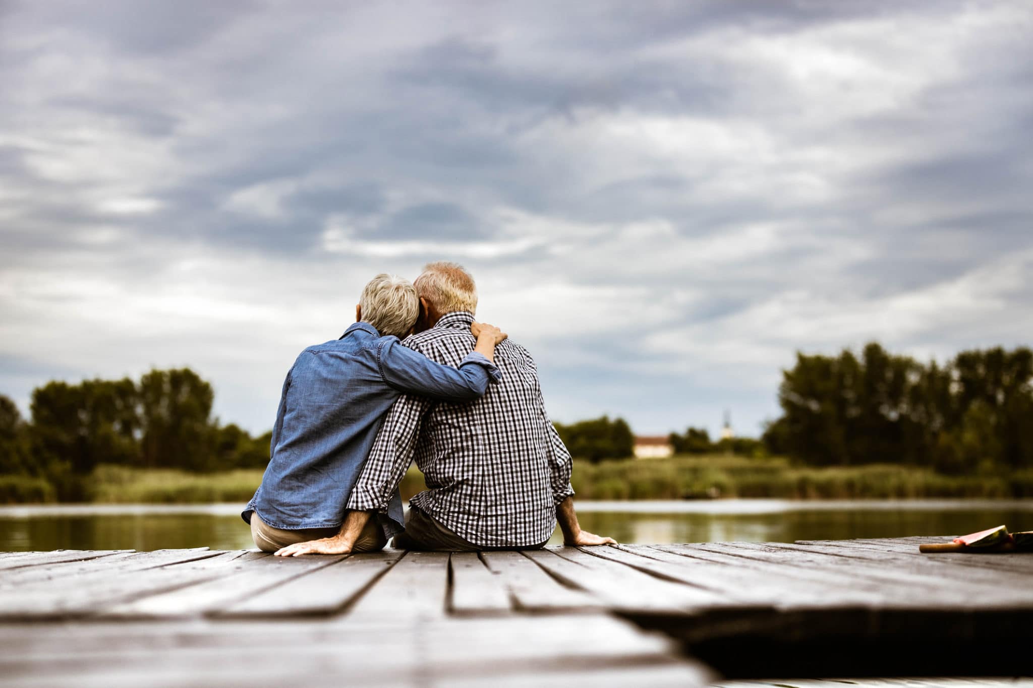 old couple sitting on a dock