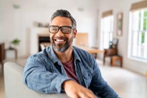 Happy,Mature,Middle,Eastern,Man,Wearing,Eyeglasses,Sitting,On,Couch.